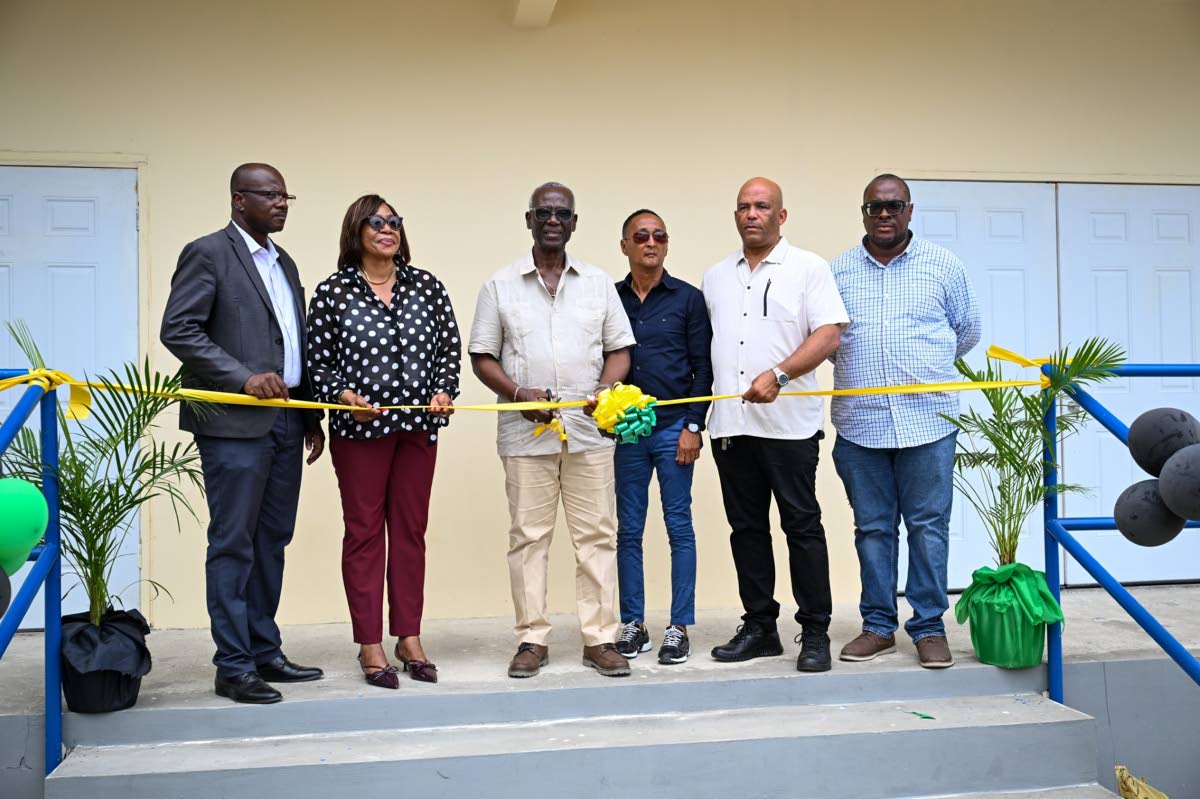 Minister of Local Government and Community Development,Desmond McKenzie (third left), and Mayor of Morant Bay, Councillor Louis Chin (third right), lead the ribbon-cutting to signify the opening of the St Thomas Night Shelter on March 27. Joining them are 
