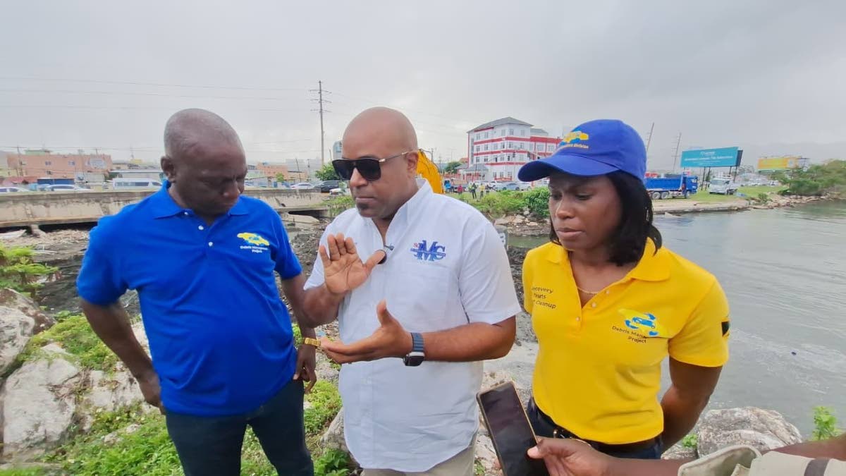 Dwight Crawford (centre), deputy mayor of Montego Bay, stresses the importance of keeping the South Gully clear to prevent flooding while Audley Gordon (left), executive director of the National Solid Waste Management Authority, and Shenique Johnson, deput