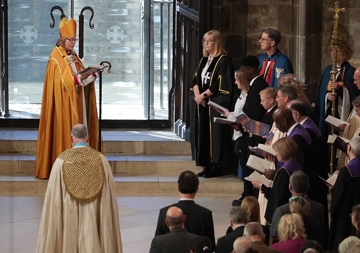 The Archbishop of Canterbury Dame Sarah Mullally is greeted by local schoolchildren Brooke, Macanthony and Solomon, from John Wallis Academy in Ashford, representing the cathedral gatekeepers, during the Enthronement Ceremony installing hery as the 106th A
