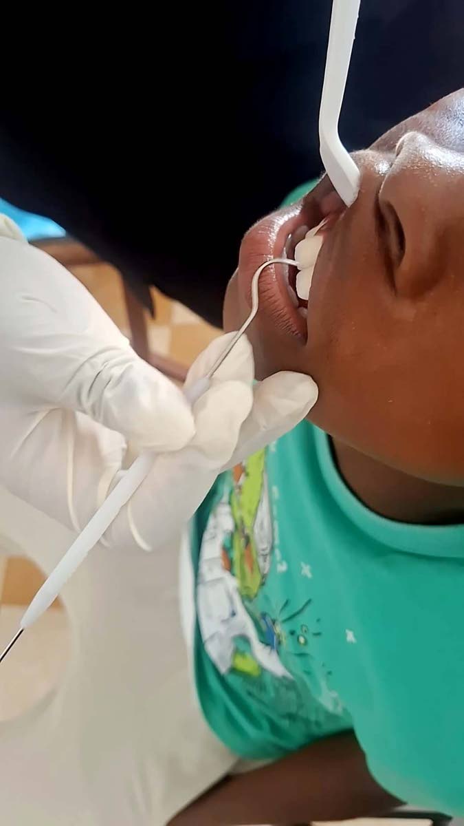 A child has his teeth examined on the second day of the Santa Cruz Family Dental outreach at Refuge Temple Ministries in Myserville, St Elizabeth.