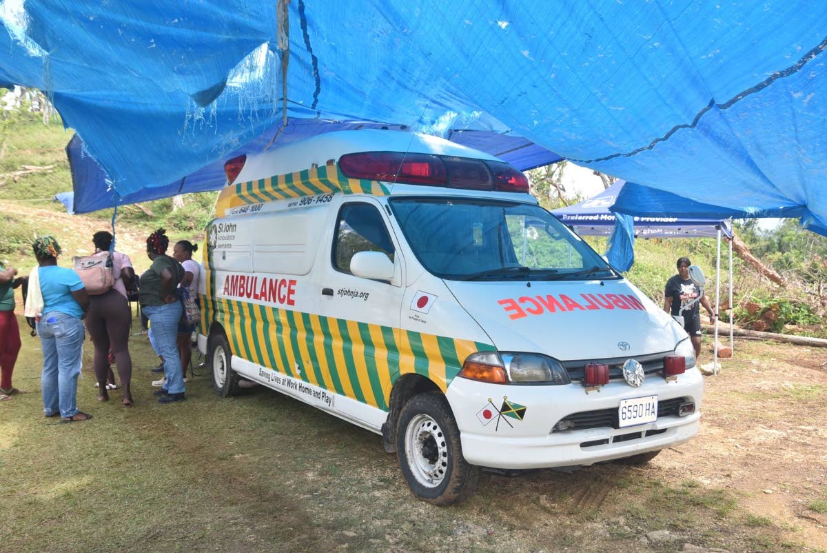 Residents of Harmony Hall, St Elizabeth, patiently gather under a tarpaulin at the entrance of the Shiloh Apostolic Church in Harmony Hall, St Elizabeth, awaiting medical checkups by St John Ambulance Jamaica. The team of medical volunteers was brought to 