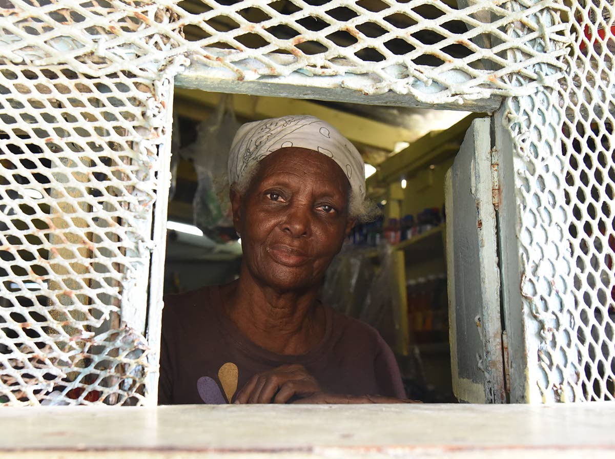 Cislyn Tulloch prepares to serve a customer in the shop at her home in Windsor, St Ann.
