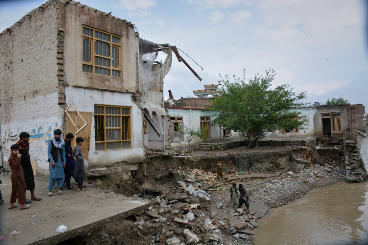Residents inspect a building that partially collapsed due to heavy flooding in Jalalabad, Afghanistan, Saturday, April 4, 2026. (AP Photo/Wahidullah Kakar)