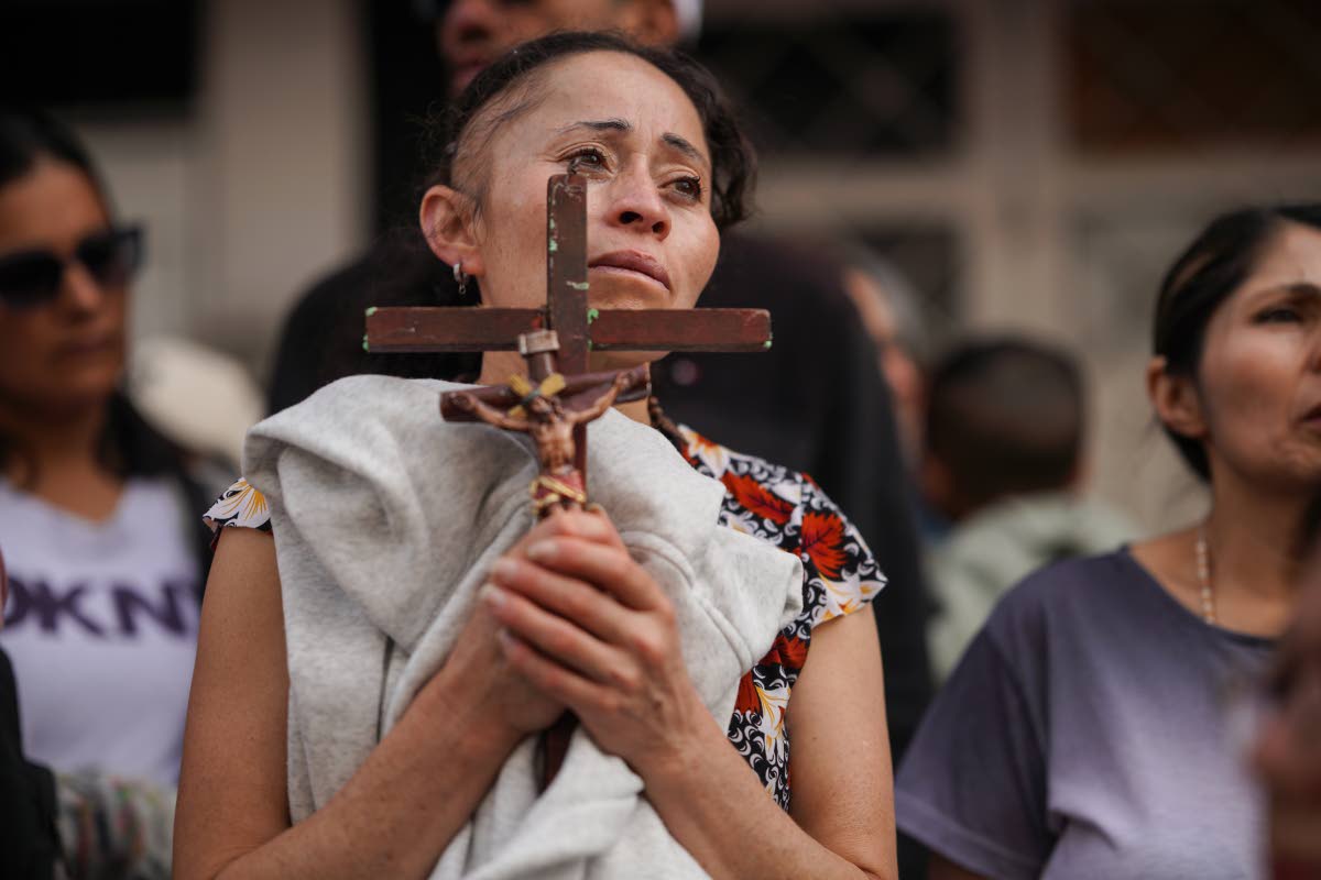 A devotee holds a cross during a Good Friday procession in the Ciudad Bolivar neighbourhood of Bogota, Colombia.
