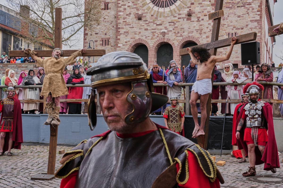 An amateur actor performing as Jesus, right, is fixed on a cross during the traditional Good Friday procession organised by the Italian community in Bensheim, Germany.