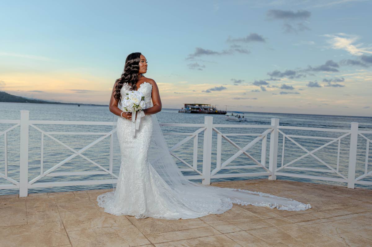 Chelsea radiates elegance as she holds a bouquet of white roses, wearing a gown from New York-based Pantora Bridal, owned by Jamaican-American designer Andrea Pitter.