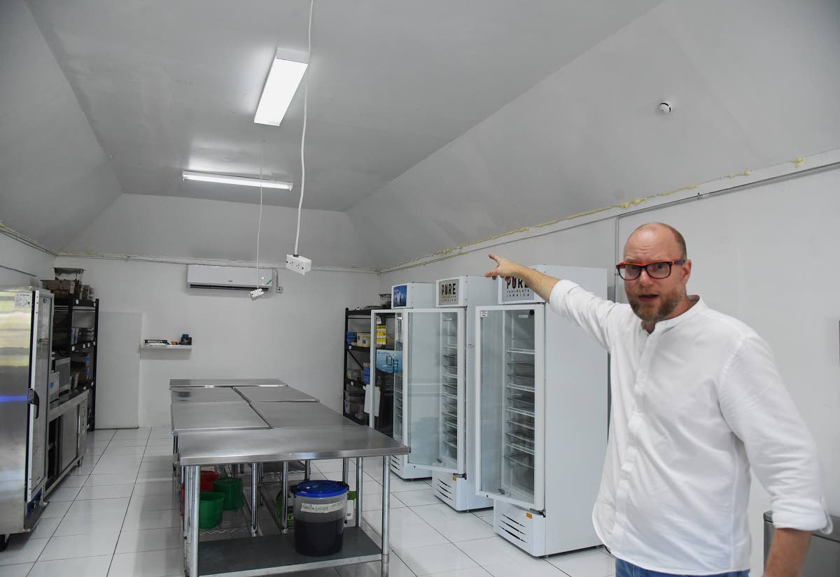 Wouter Tjeertes, co-founder of Pure Chocolate, shows where the roof had collapsed after the guango tree fell during the passage of Hurricane Melissa on October 28, 2025.