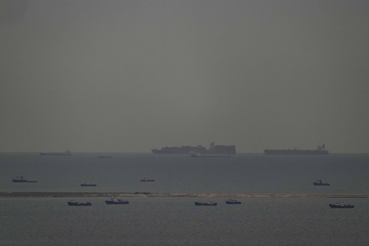 Fishing boats dot the sea as cargo ships, in the background, sail through the Arabian Gulf toward the Strait of Hormuz off the United Arab Emirates, Friday, March 27, 2026. (AP Photo)