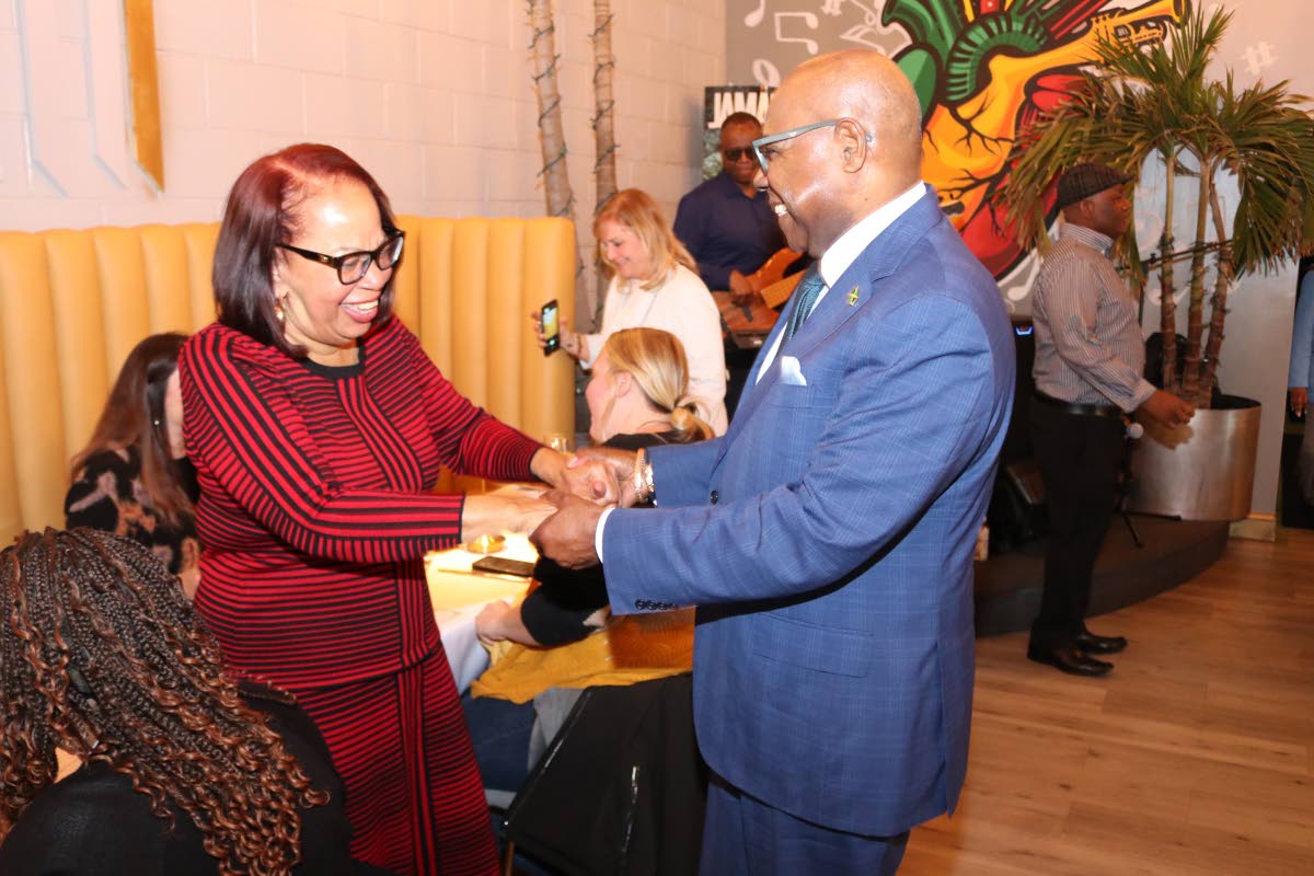 Tourism Minister Edmund Bartlett shares a light moment with Maryland-based travel agent, Claire Robinson at the Jamaica Tourist Board Travel Advisory Reception in Laurel, Maryland, on Tuesday.