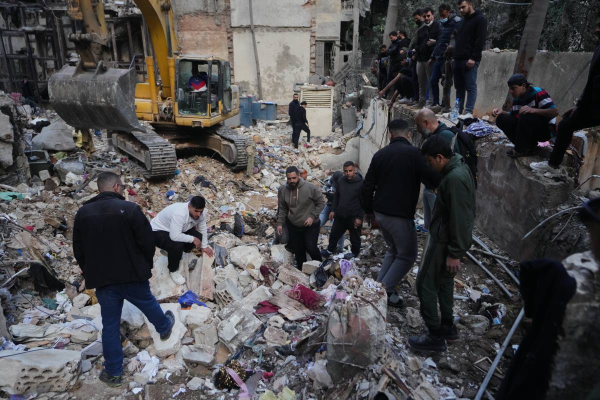 Civilians and rescue workers search through rubble at the site of a building where efforts continue to recover the body of missing woman Zahraa Aboud, 26, after it was destroyed in an Israeli airstrike on Wednesday, in central Beirut, yesterday. 