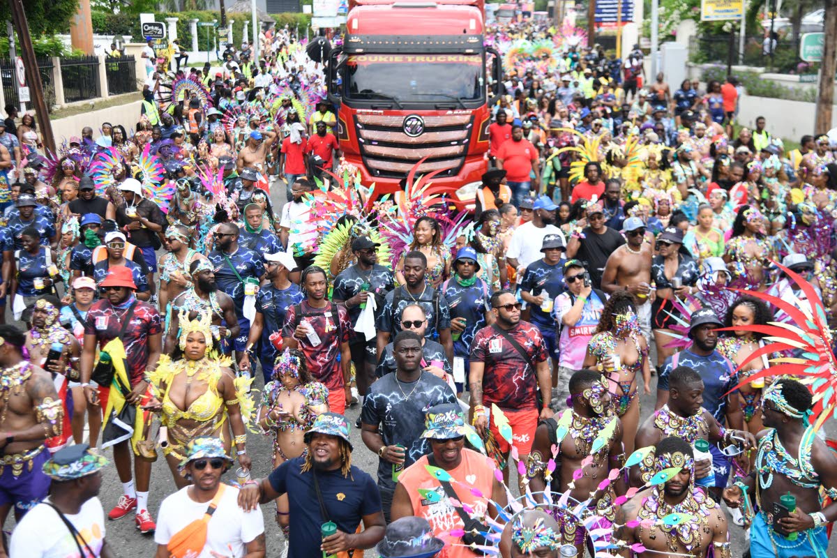 Gen XS masquerades pause their revelery as they make their way down Hope Road in St Andrew pass the Andrews Memorial Hospital on Carnival Sunday. Kibwe McGann, a director of the band, said foreigners returned in their numbers, and the local participation m
