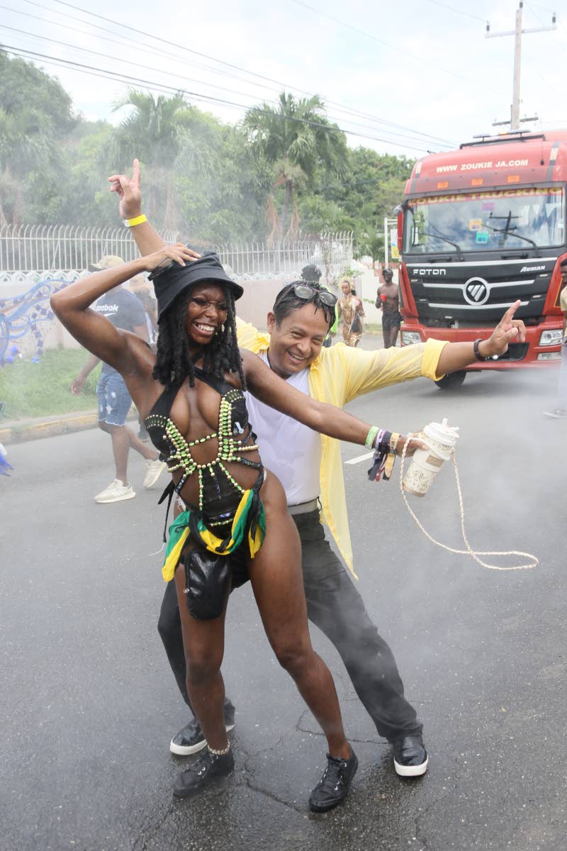 Tynekia Rogers from North Carolina dances with Andrew Zor under a mist of water during the Yard Maas Carnival in Jamaica Road March. 