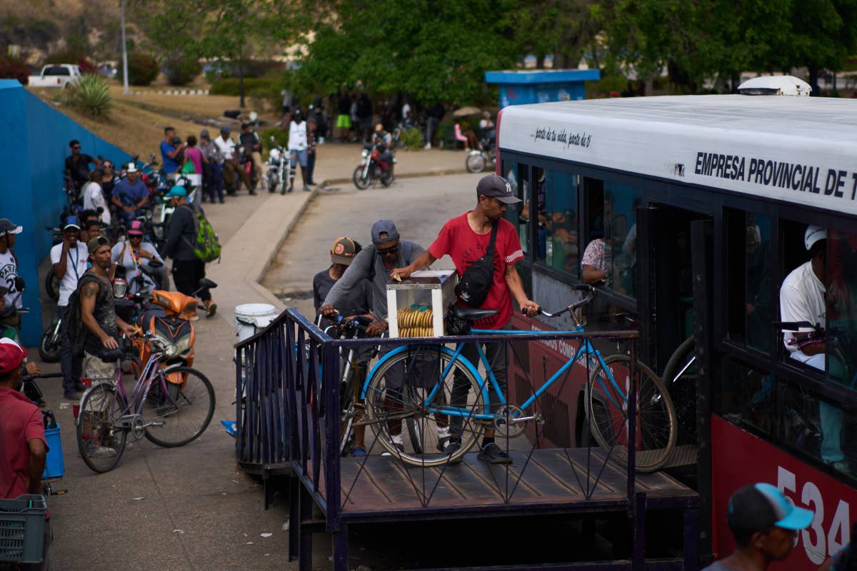 People load their bicycles onto a public bus to cross the Bay Tunnel in Havana, Wednesday, April 8, 2026. (AP Photo/Ramon Espinosa)