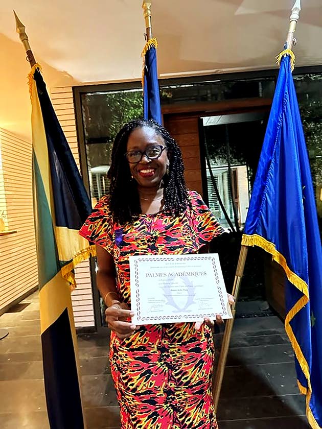 Shelley Wong displays her certificate following her appointment as a Knight in the Order of the Palmes Académiques, a French national honour recognising contributions to education and culture.