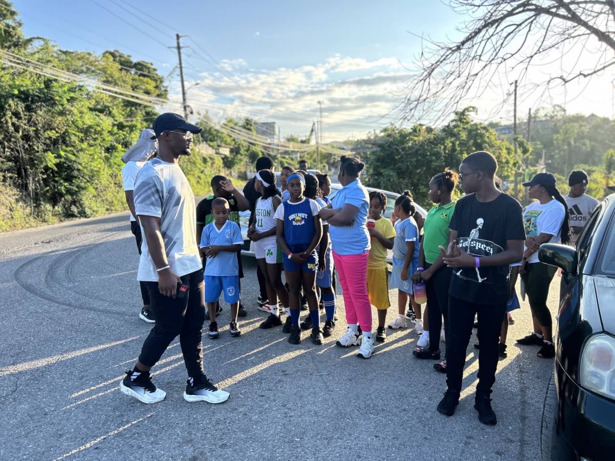 Fitness instructor Tajay Campbell leads participants after warm‑up activities at Sheffield Primary’s 2K walk/run.
