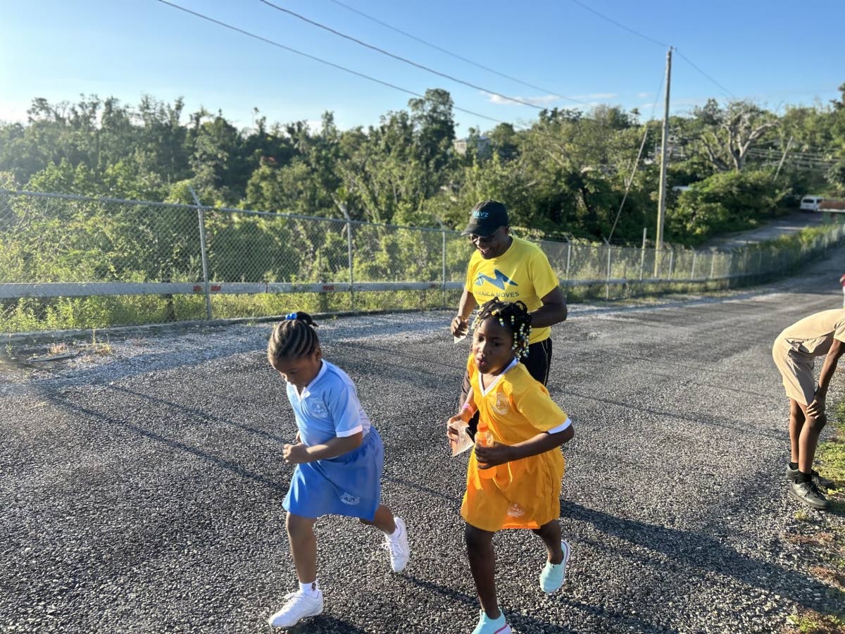 Sheffield Primary students race towards the finish line in the 2K walk/run alongside Westmoreland health‑promotion officer Gerald Miller.