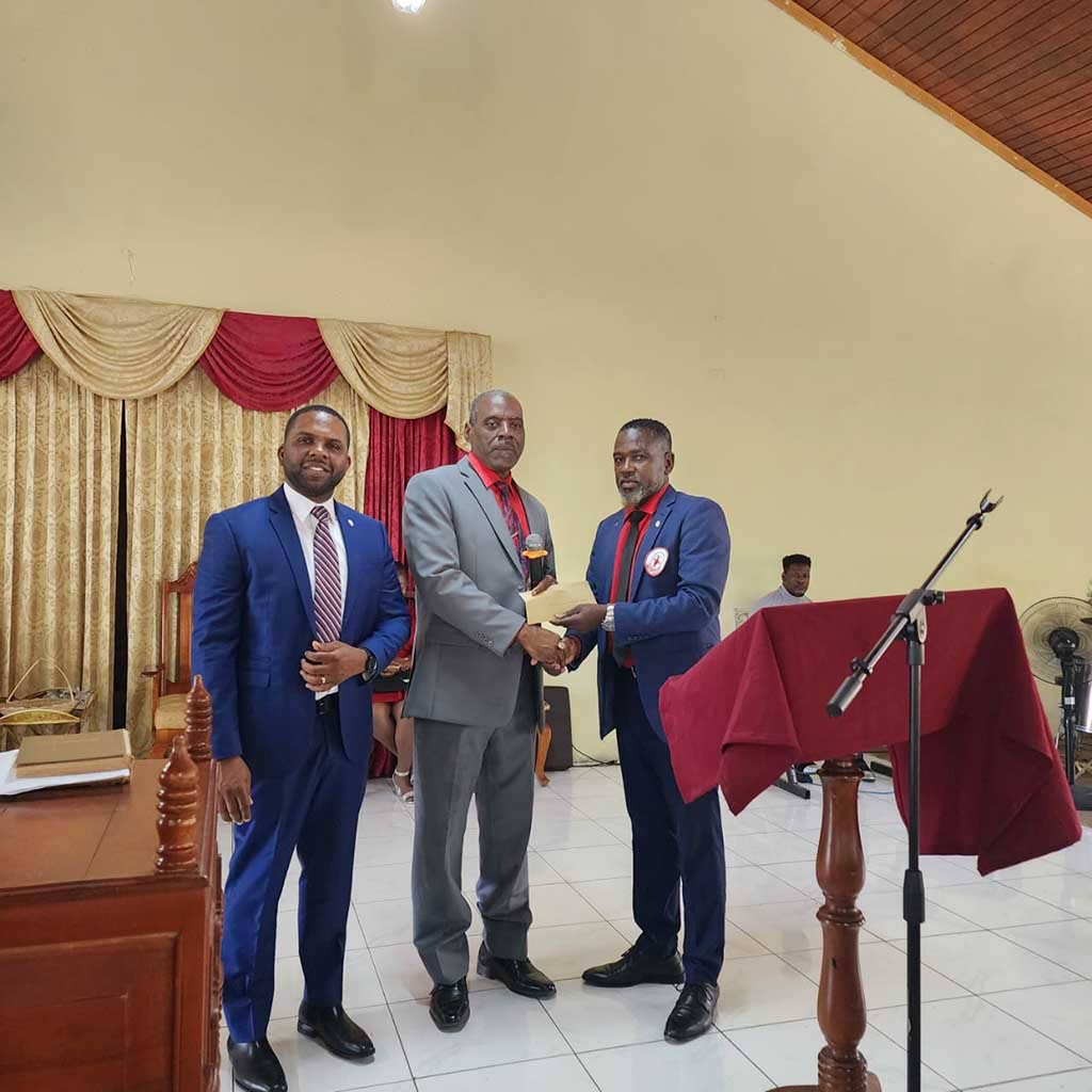 Floyd Hitchman (right), president of the St James Chapter of the Lay Magistrates Association of Jamaica, presents an envelope containing an undisclosed financial contribution to Paul Blake, pastor of the Norwood Wesleyan Holiness Church and the chapter’s