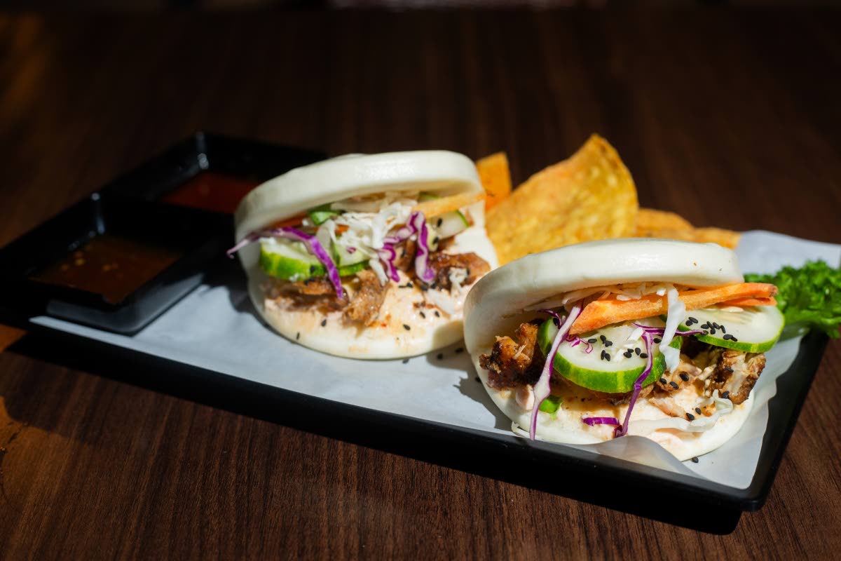 The Korean fire and sweet sesame chicken bao buns are served with a side of chips.