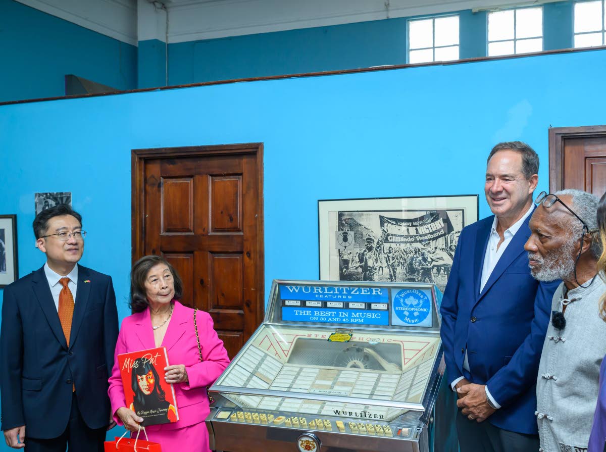 Hotelier Christopher Issa (second right) presents a 1962 Wurlitzer jukebox to the Jamaica Music Museum as executive director Herbie Miller (right) looks on. Also sharing in the moment are Chinese Ambassador to Jamaica Wang Jinfeng (left) and VP Records co-