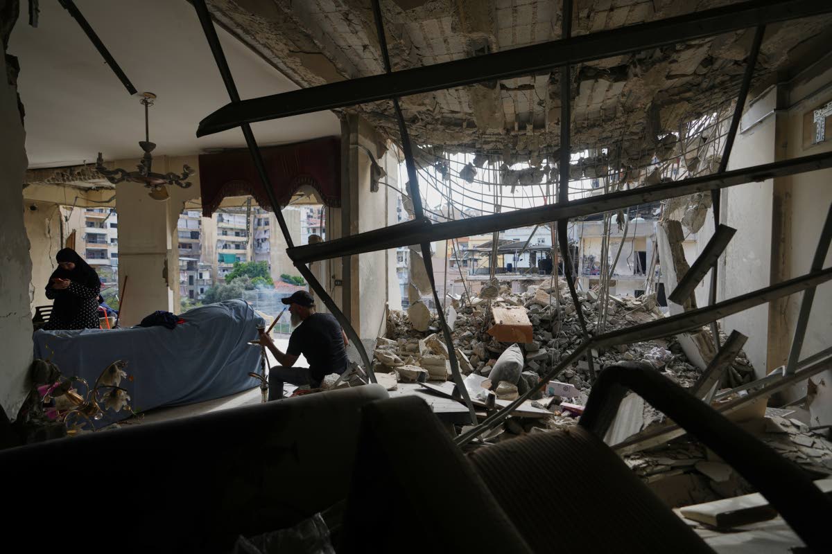 Fadi Al Zein, who lost both his homes in Israeli strikes in his village of Khiam and in Dahiyeh, smokes a water pipe inside his heavily damaged home in Beirut's southern suburbs of Lebanon on April 25, 2026. (AP Photo/Hassan Ammar)