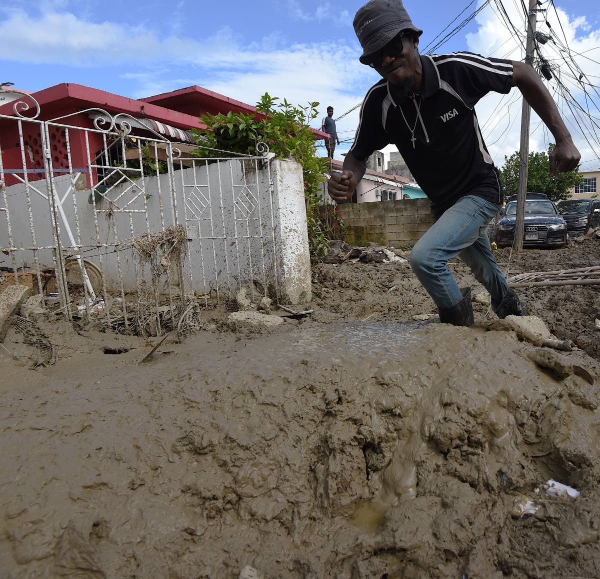 A resident of Catherine Hall struggles to walk through several inches of mud dumped in the community last November, days after three rivers overflowed their banks and the sea came inland, creating a massive flood in the area.