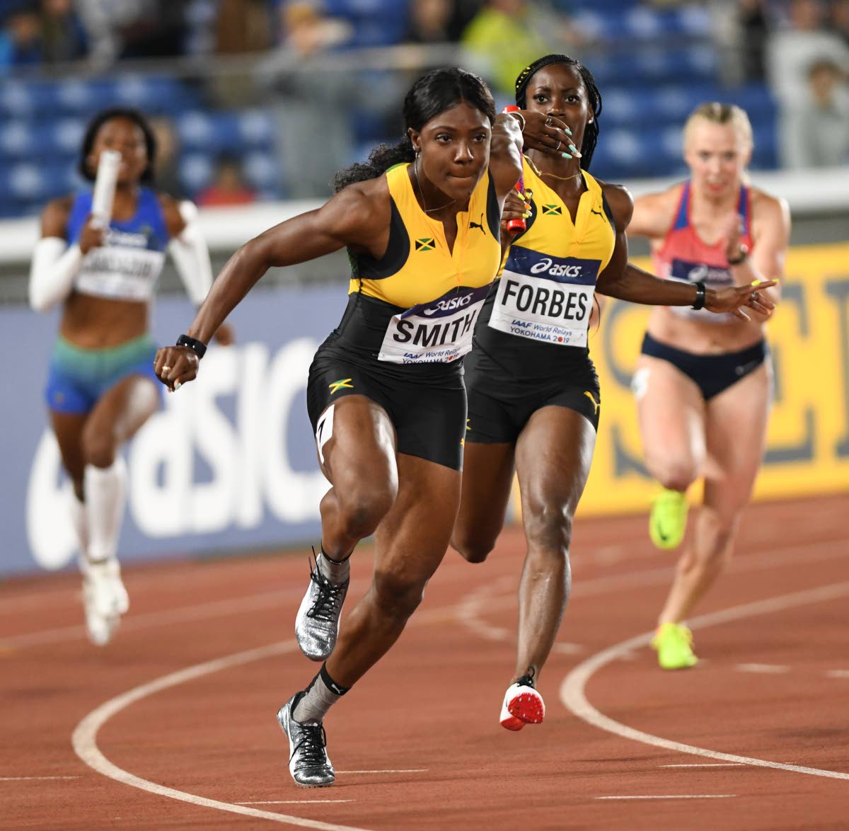 Jonielle Smith (left) receives the baton from Shashalee Forbes in the women’s 4x100-metre relay heats at the 2021  World Athletics Relays in Yokohama, Japan.