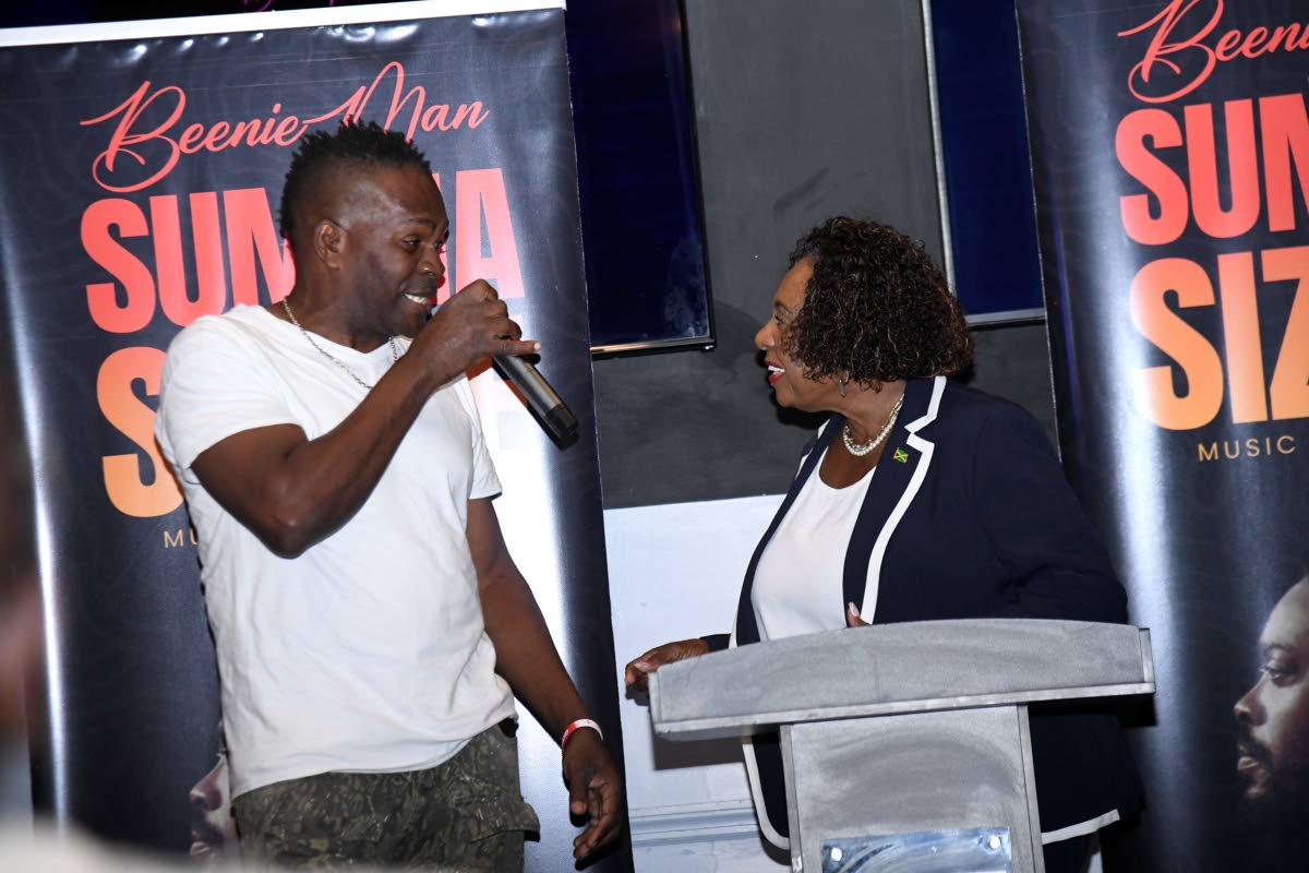 Ruff Kutt drummer, Ricardo Davis, shares a light moment with Minister Grange at Wednesday’s launch of Summa Sizzle.