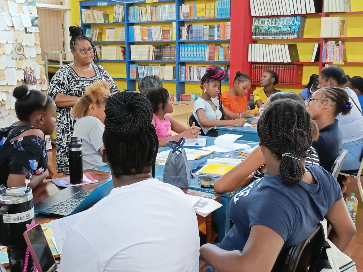  Marilee Moody, senior librarian at the St James Parish Library in Montego Bay, leads an animated discussion on the importance of literacy with several young girls from Flankers.  
