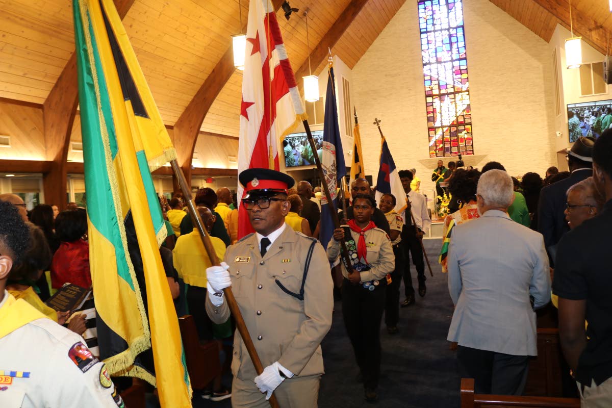 Deputy Security Attaché at the Embassy of Jamaica, Superintendent Ewon Simms, bearing the Jamaican flag, leads the procession signaling the start of the service of thanksgiving marking Jamaica’s 64th anniversary of Independence and the 188th anniversary