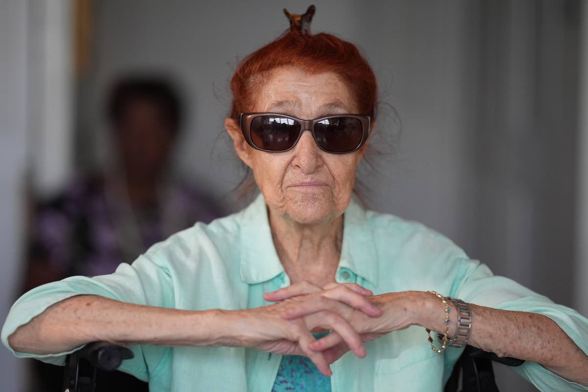 Anna Fischbein speaks about the loss of a beloved Haitian home healthcare worker whose Temporary Protected Status expired last week, as another healthcare worker with American citizenship waits behind to drive her to a doctor’s appointment, during an int