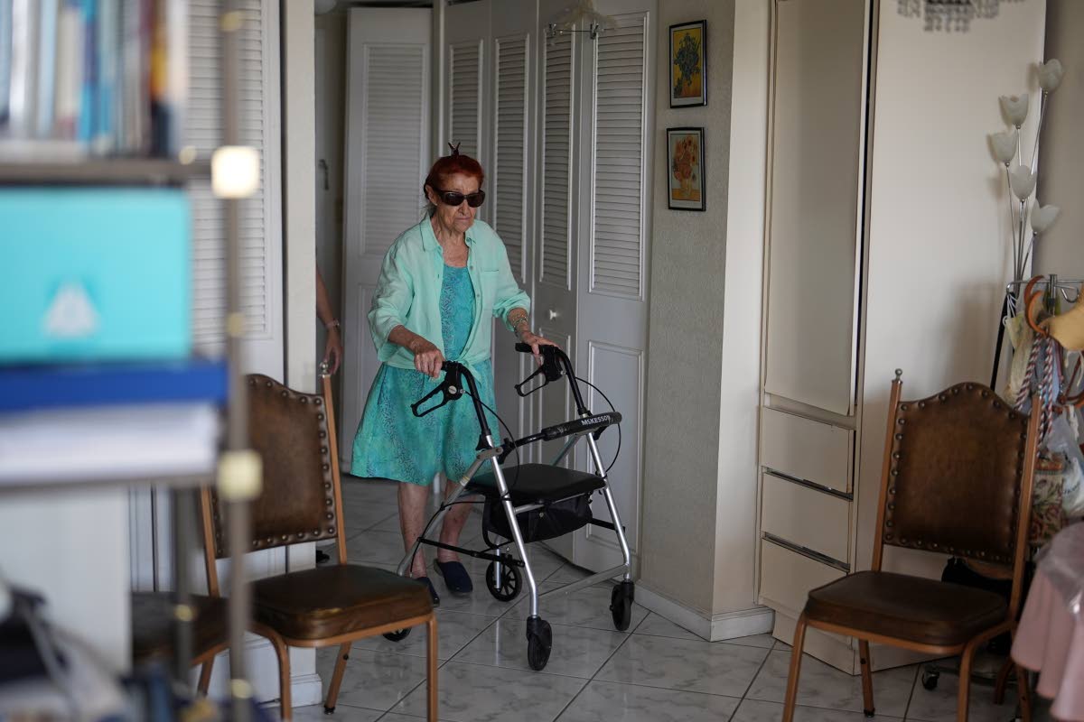 Anna Fischbein walks inside her apartment during an interview about the loss of a beloved Haitian home healthcare worker last week.	