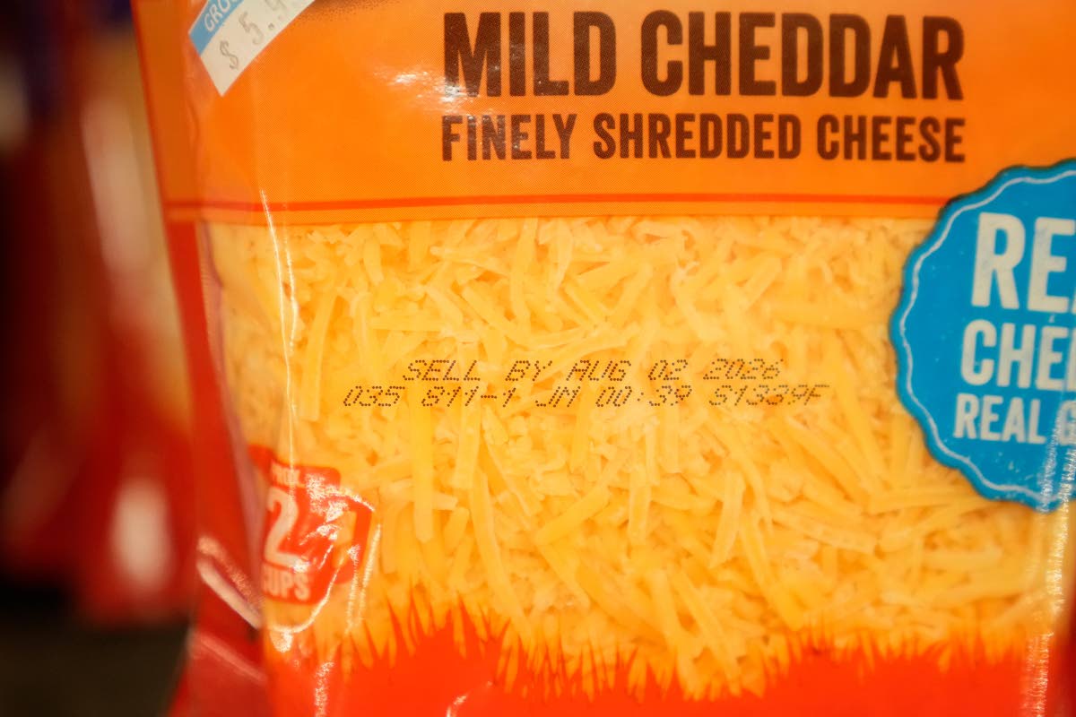 A Sell By date is stamped on package of cheese.