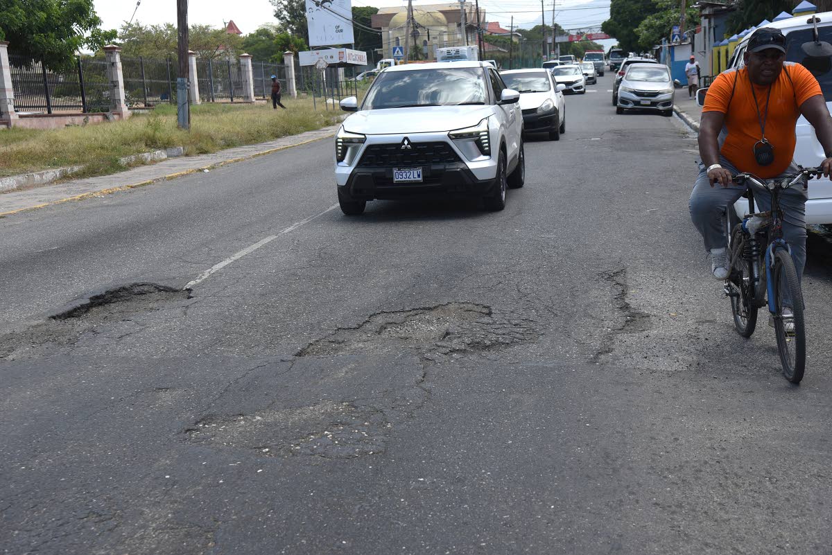 
Road users navigate a section of Marescaux Road in front of the Ministry of Finance and the Public Service at National Heroes Circle in Kingston last week.