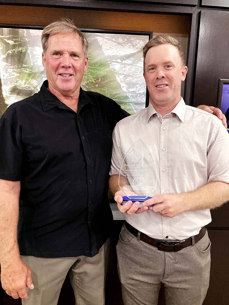 David Lambe (left) and his son, Blake Lambe, of G.H. Lambe & Son attend the Seasonal Agricultural Worker Programme (SAWP) Diamond Jubilee Awards Reception.