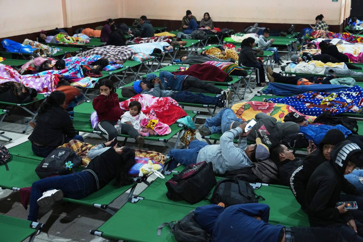 Families evacuated from areas surrounding the Fuego Volcano rest at a temporary shelter in San Juan Alotenango, Guatemala, Tuesday, Aug. 4, 2026. (AP Photo/Moises Castillo)