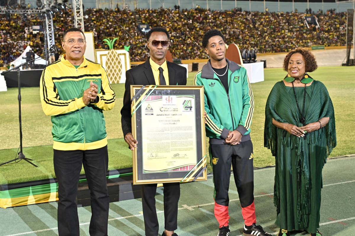 Legendary reggae singer Wayne Wonder (second left) celebrates with his son, Daivon (second right), as he receives the Reggae Icon Award from Prime Minister Dr Andrew Holness and Minister of Culture, Gender, Entertainment and Sport Olivia Grange at Thursday
