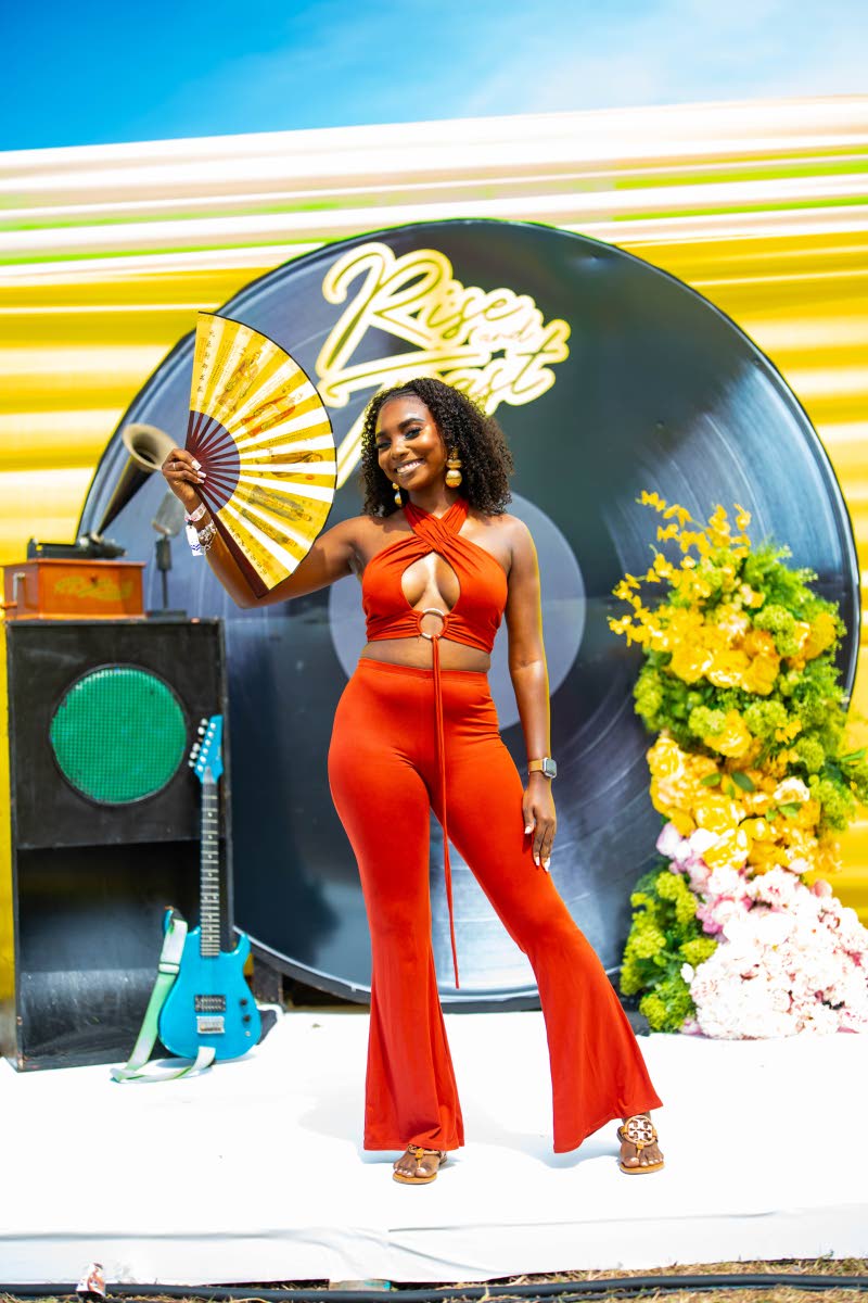 Lecturer Jamelia  Cruickshank embraces warm tones in a vibrant rust-coloured two-piece set, striking a playful pose for the lens. 