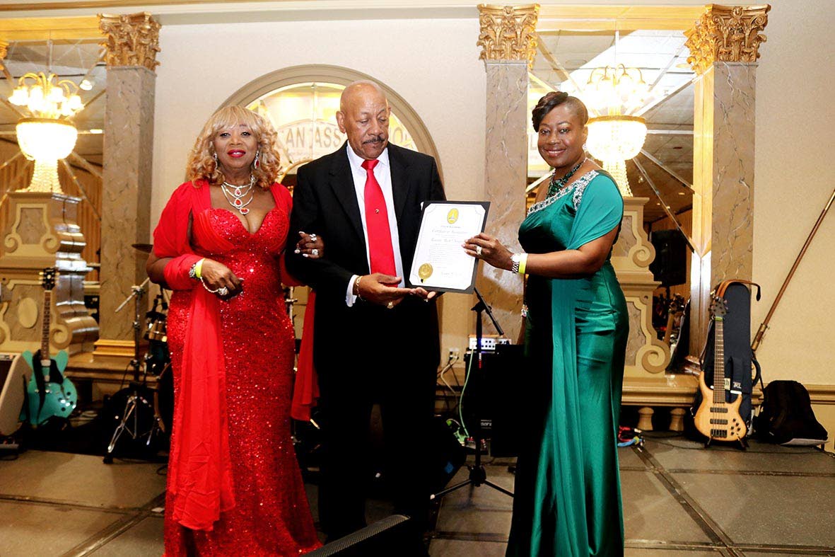 Ericka Blake Morgan (right) presents a citation on behalf of Baltimore Mayor Brandon M. Scott to JAM President Ricardo ‘Rick’ Nugent (centre), recognising his leadership and more than four decades of service to the Jamaican community. At left is his wi