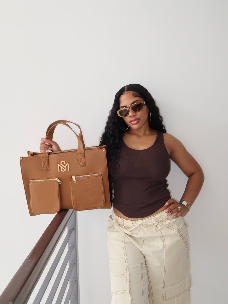Shacqueal Major, founder of SM Kollection, carries the brand’s signature tote in tan.
