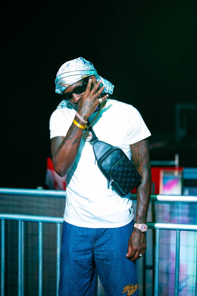 Dancehall artiste Aidonia kept his Late Check Out look relaxed in a crisp white T-shirt and denim, accessorised with a printed headscarf, dark shades and a Louis Vuitton crossbody bag.