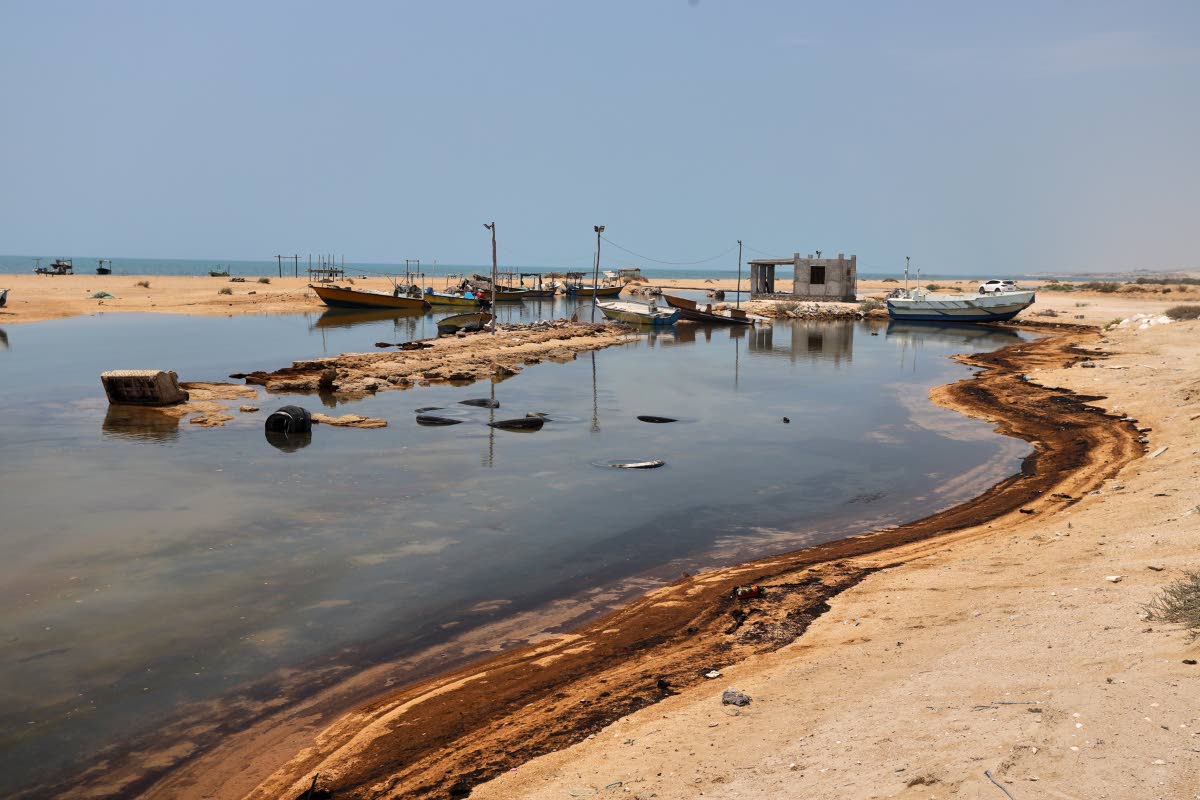
Oil residue lines the shore near fishing boats on Qeshm Island, Iran, amid ongoing wartime attacks on vessels and infrastructure in and around the Strait of Hormuz, though the spill’s source has not been independently determined.