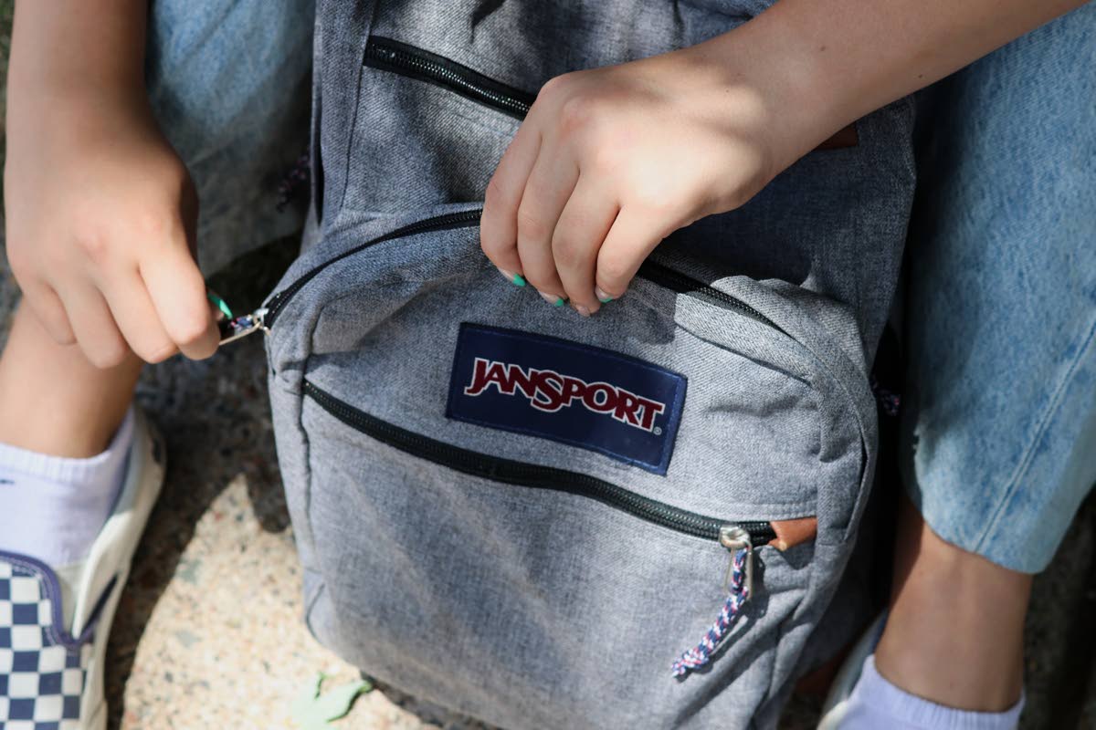 Middle school student Claire Knoth, 13, zips up her backpack after packing it with school supplies.