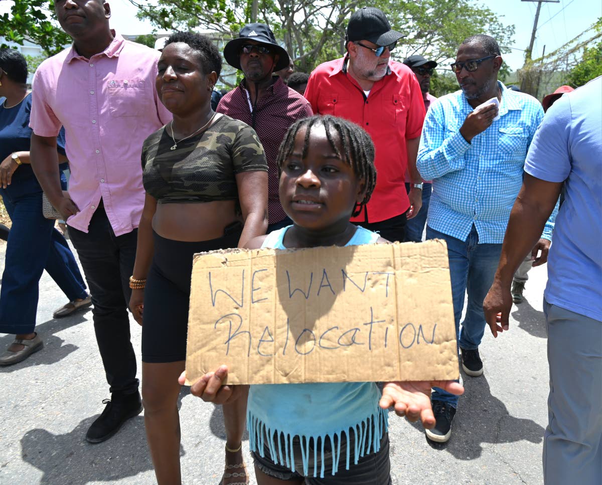 Eight-year-old Arhiana Murray holds up a placard after her home was demolished in Cooper’s Pen, Trelawny, last week.