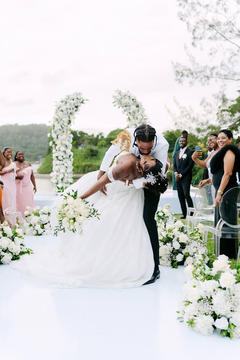 In the presence of friends and loved ones, the newly-weds share a classic romantic dip kiss.