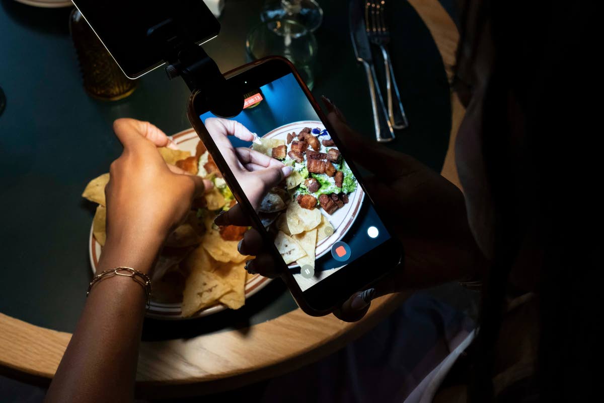 Aiesha Beasley films a detail shot of her chips and guacamole during the opening of Padeland.