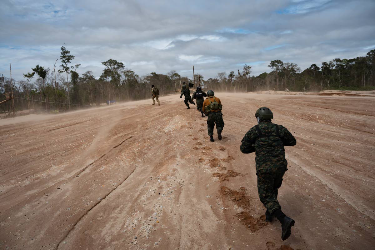 Peruvian Navy soldiers run as they get off a helicopter during an operation to combat illegal mining in the Tambopata National Reserve in Puerto Maldonado, Peru, on August 11.
