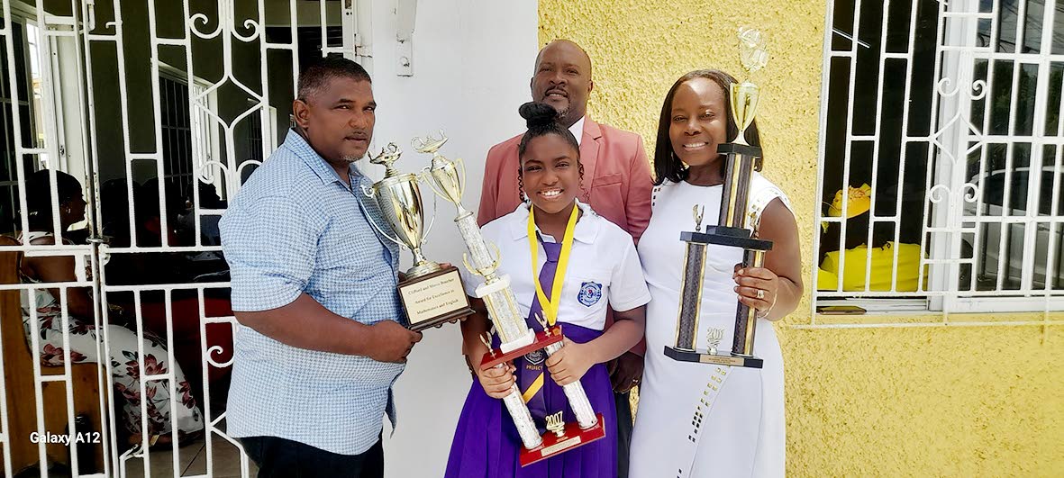 Gabrielle Dajue (centre) with her parents, Robert Dajue (right) and Phillipea Dajue, while Crescent All-Age School Principal Harris Francis stands in the background. 
