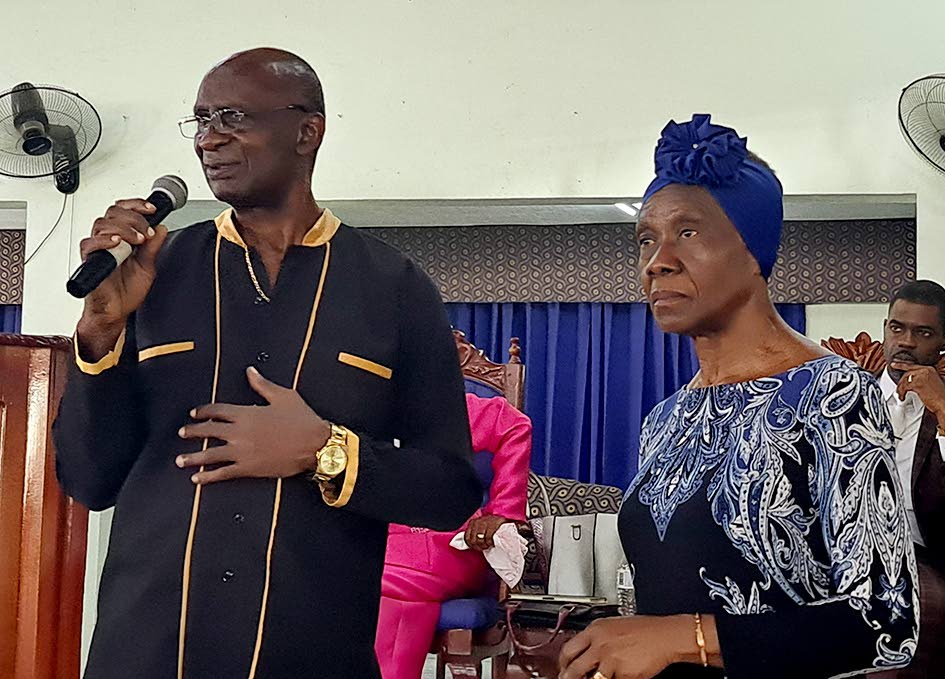 Claude Beecher, founder of the Beecher Foundation, delivers remarks at the Oneness Apostolic Church in Spanish Town as Pauline Beecher listens.