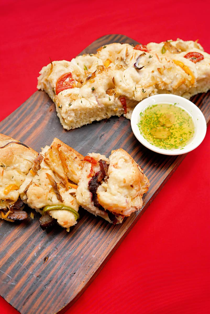 A focaccia sandwich layered with barbecue pork, sorrel jam and seasoned salt fish. 