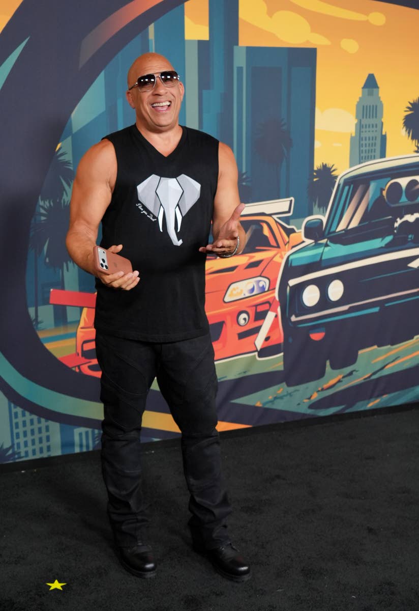 Vin Diesel keeps it casual in an all-black look featuring a sleeveless muscle shirt and matching dark trousers.